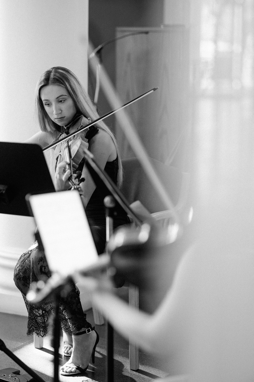 Tali playing violin seated